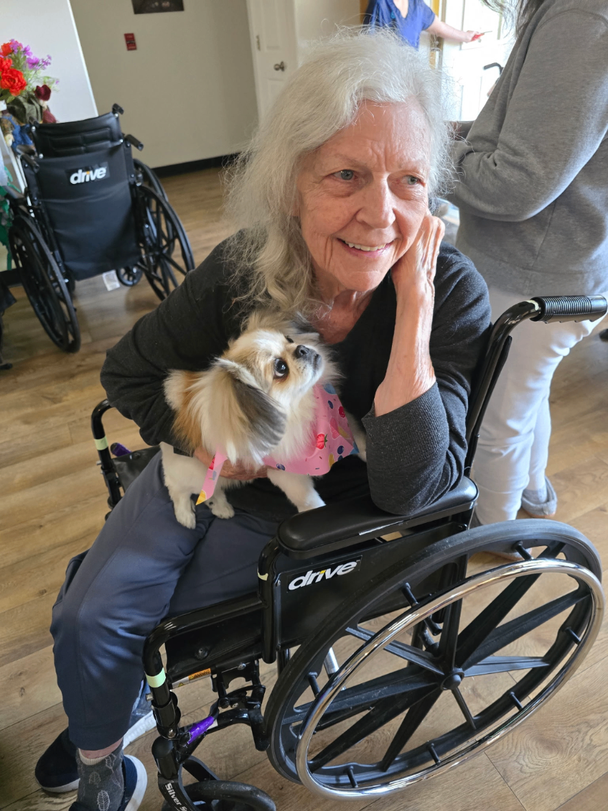 Resident cuddling a sweet pup in the lobby