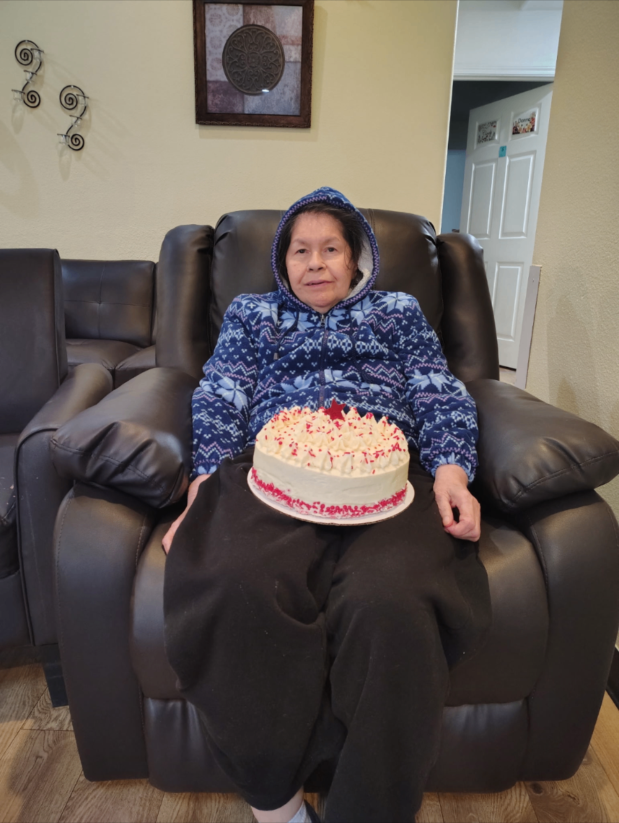 Resident with a birthday cake in the recliner